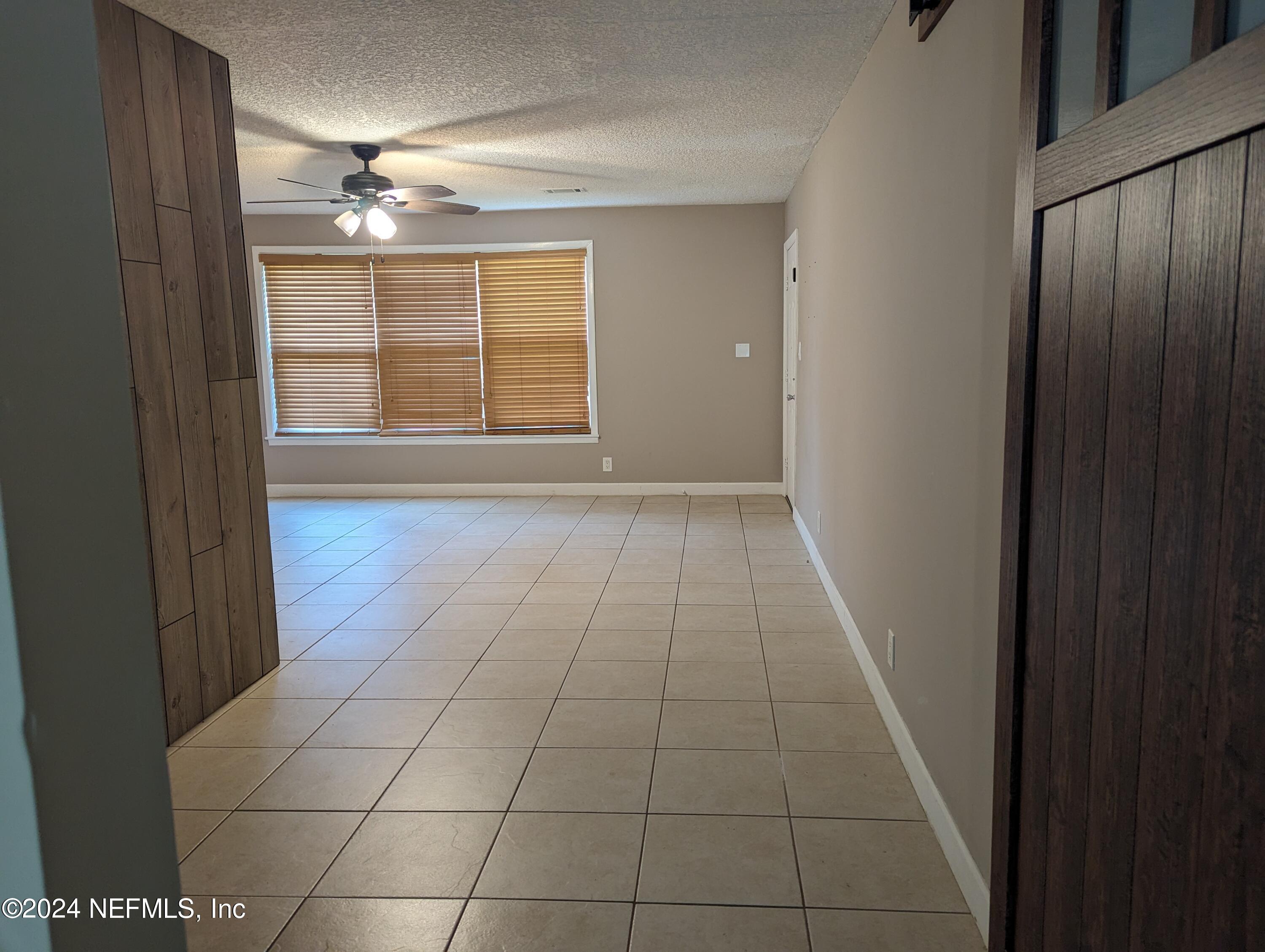 5120 Oakside Drive Jacksonville, FL 32244 - Photo 22 of 24 a view of an empty room with window and chandelier fan