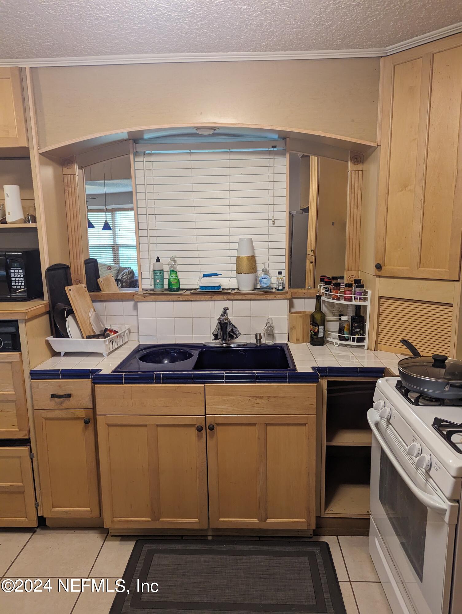 5120 Oakside Drive Jacksonville, FL 32244 - Photo 6 of 24 a kitchen with a stove a sink and a refrigerator