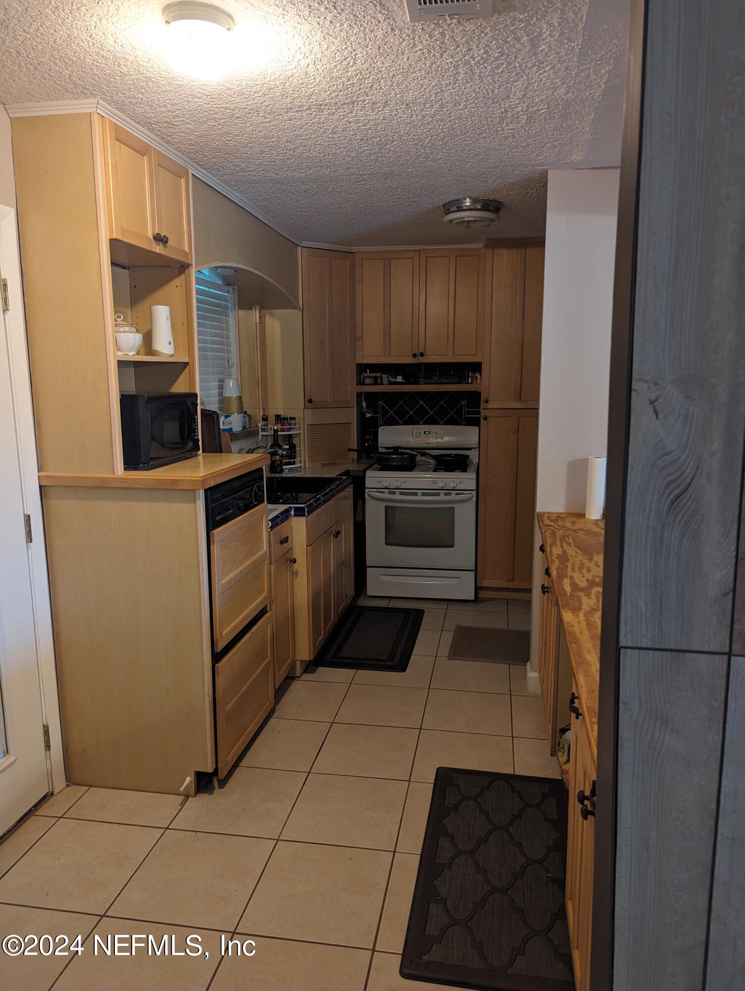 5120 Oakside Drive Jacksonville, FL 32244 - Photo 8 of 24 a kitchen with a refrigerator and a stove top oven