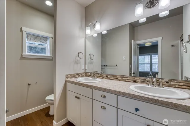 a bathroom with a granite countertop sink a toilet and a mirror