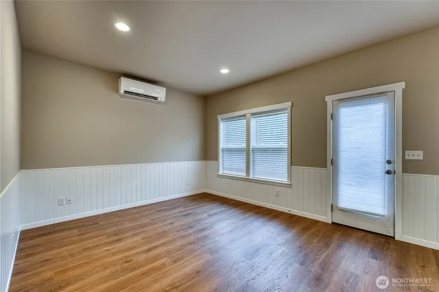 an empty room with wooden floor and windows