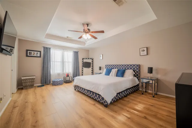 a spacious bedroom with a bed and a flat screen tv