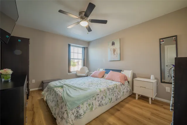 a bedroom with a bed and a flat tv screen on dresser