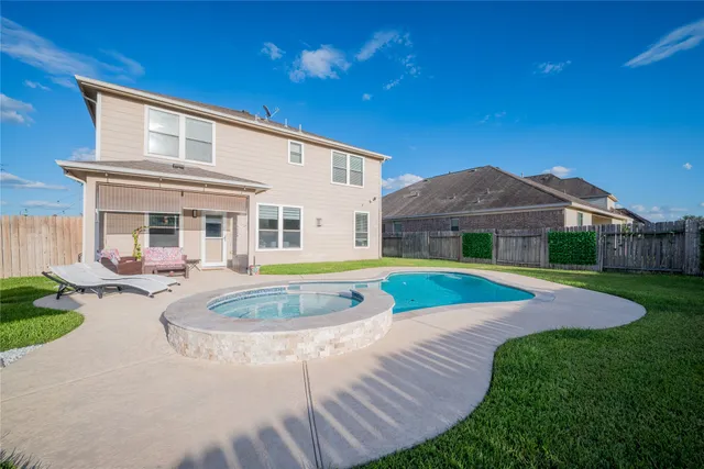 a view of house with swimming pool and yard