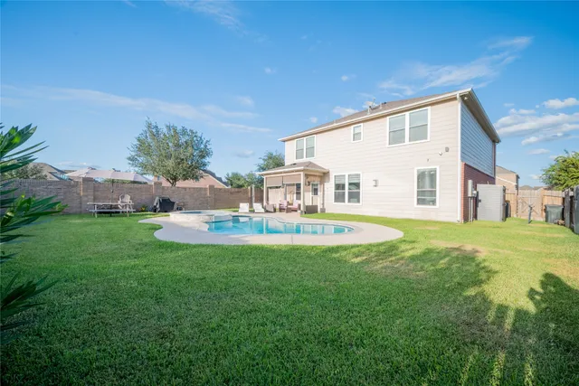 a house view with swimming pool in front of it