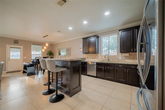 a kitchen with kitchen island granite countertop lots of counter top space and stainless steel appliances