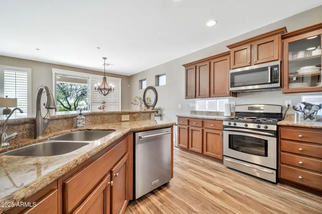 a kitchen with stainless steel appliances granite countertop a sink stove and refrigerator