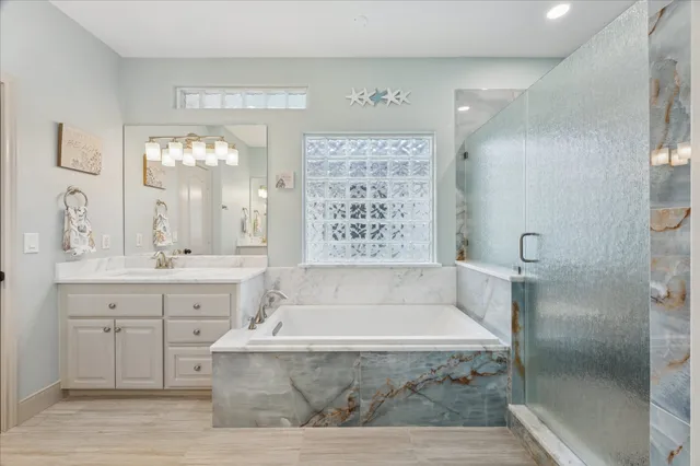 a spacious bathroom with a tub shower and sink