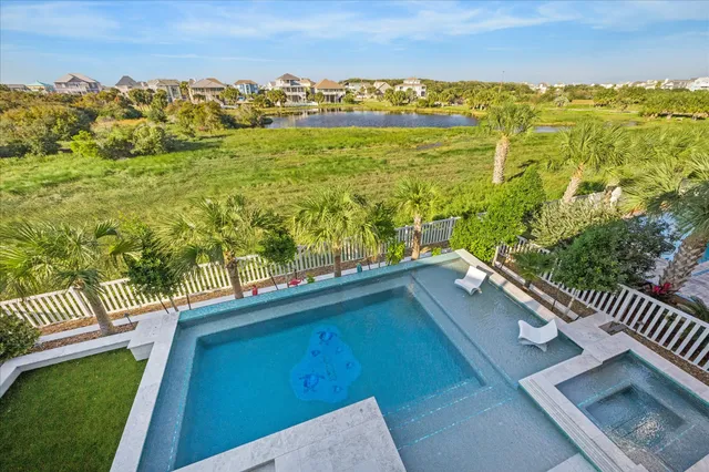 an aerial view of residential houses with outdoor space and ocean view