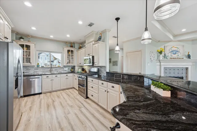 a large kitchen with granite countertop a stove a sink dishwasher and a refrigerator