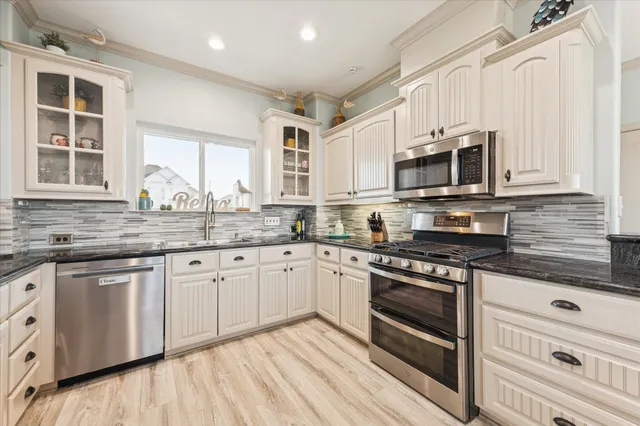 a kitchen with stainless steel appliances granite countertop a stove and a sink
