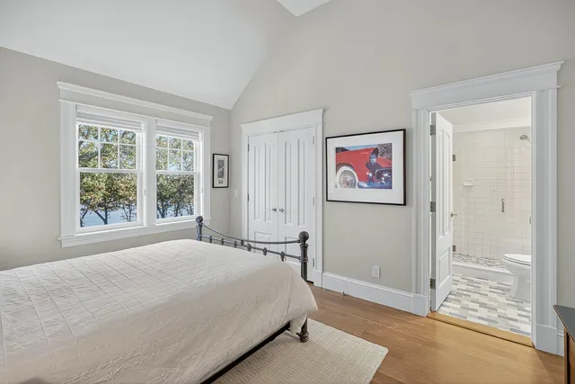 a bedroom with bed and a flat tv screen next to a window