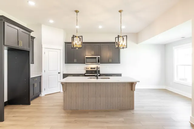 a kitchen with kitchen island a sink stove and refrigerator