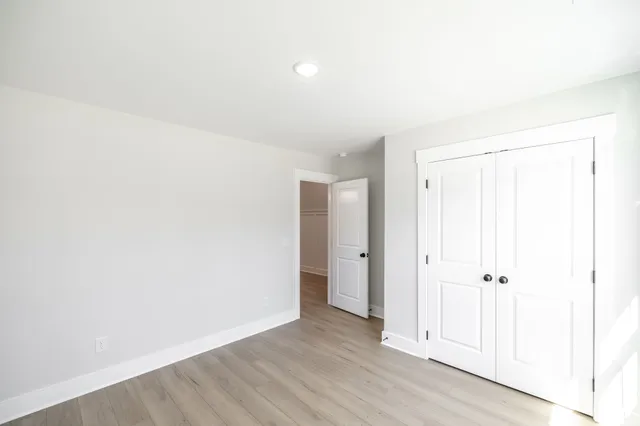 an empty room with wooden floor and closet