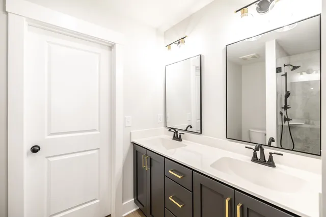 a bathroom with a double vanity sink and a mirror