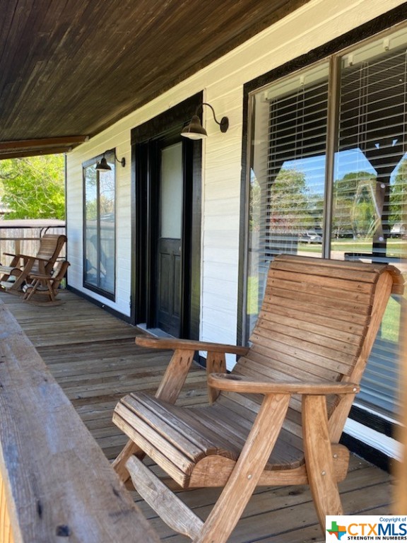 a view of a balcony with two windows and wooden floor