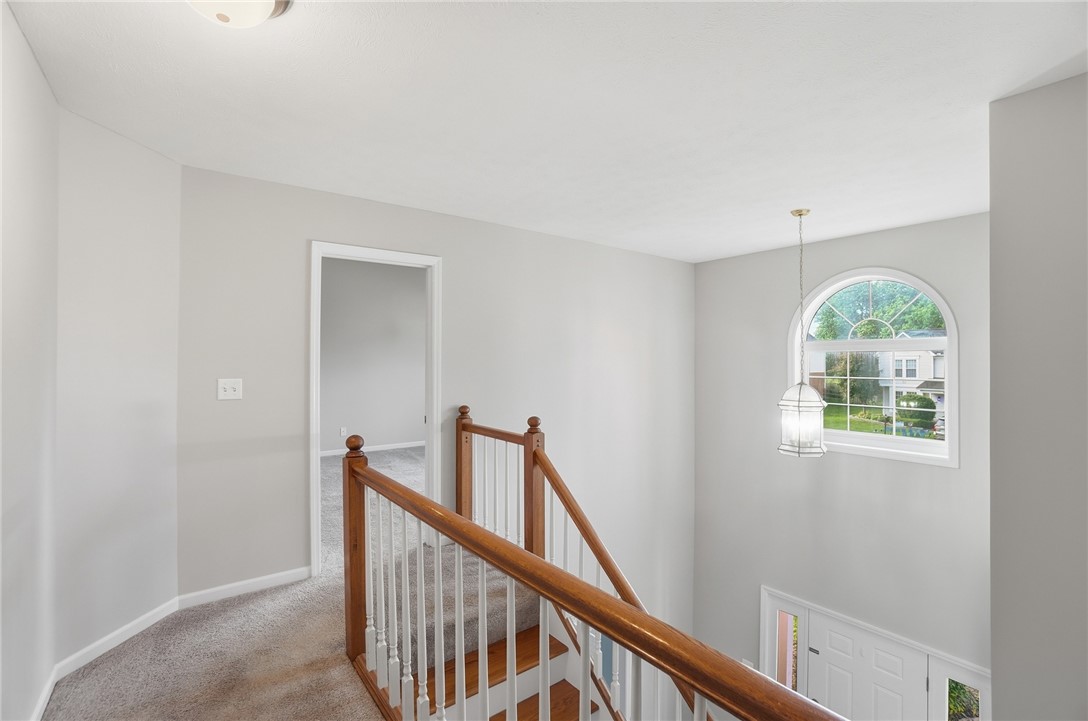 10 Chase Court Springboro, OH 45066 - Photo 32 of 75 This bright hallway connects spaces with an elegant arched window and staircase with wood railing.