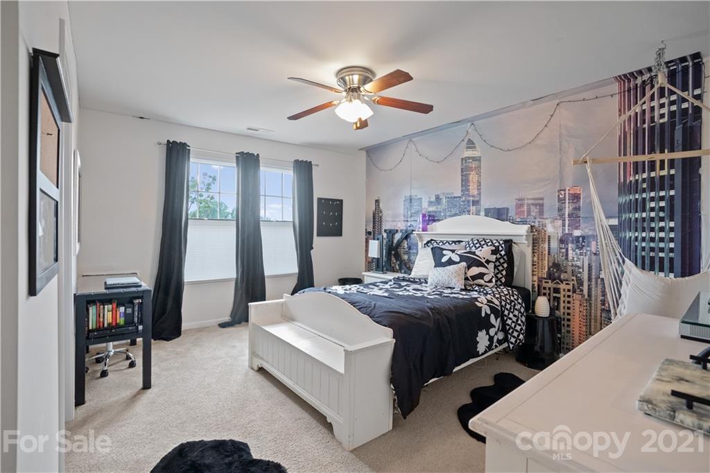 2714 Aldergrove Road Matthews, NC 28105 - Photo 15 of 23 a bedroom with bed and a chandelier