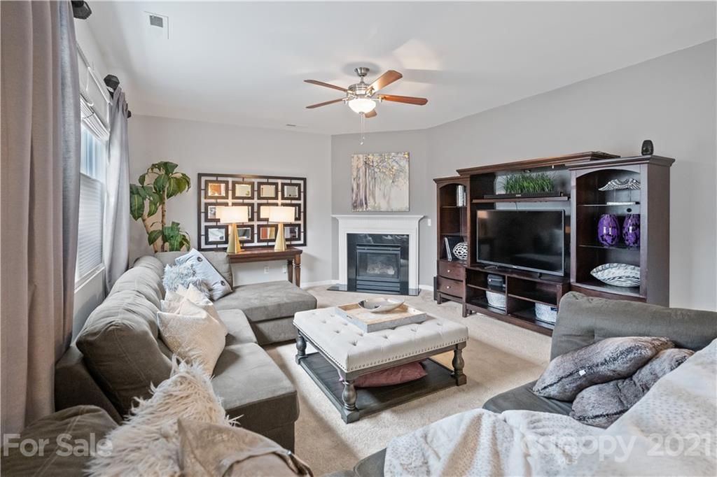 2714 Aldergrove Road Matthews, NC 28105 - Photo 7 of 23 a living room with furniture a flat screen tv and a fireplace