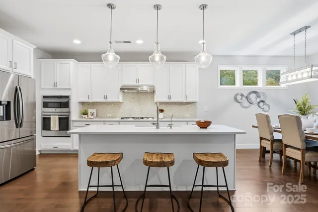 a kitchen with kitchen island granite countertop a sink a center island and cabinets