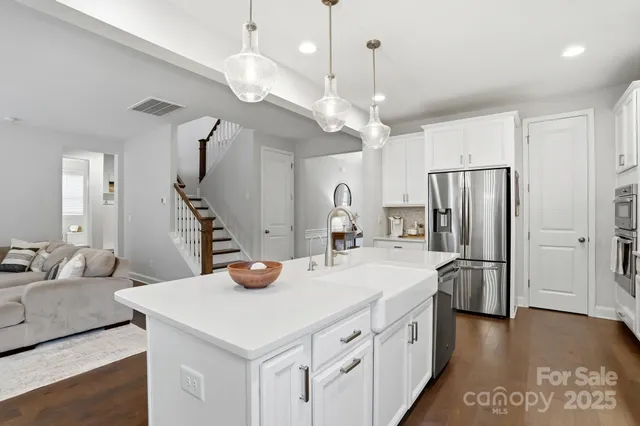 a kitchen with stainless steel appliances granite countertop a sink a refrigerator and a stove