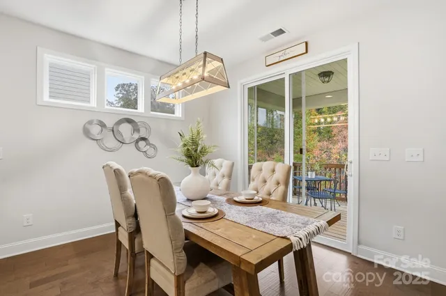 a view of a dining room with furniture a chandelier and wooden floor
