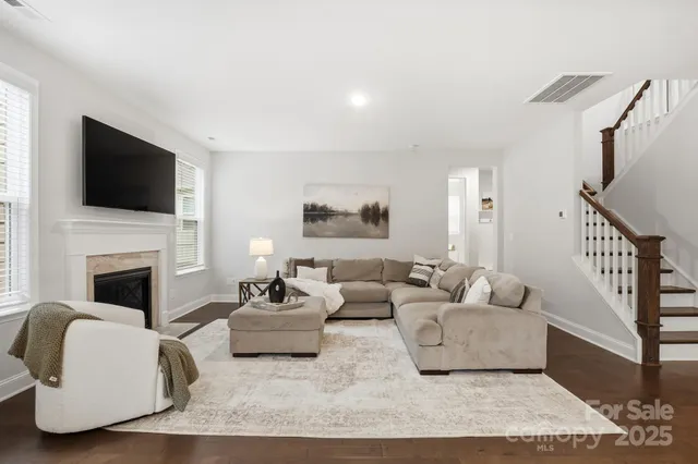 a living room with furniture a flat screen tv and a fireplace