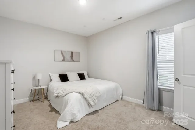 a bathroom with a granite countertop double vanity sink a mirror and a shower