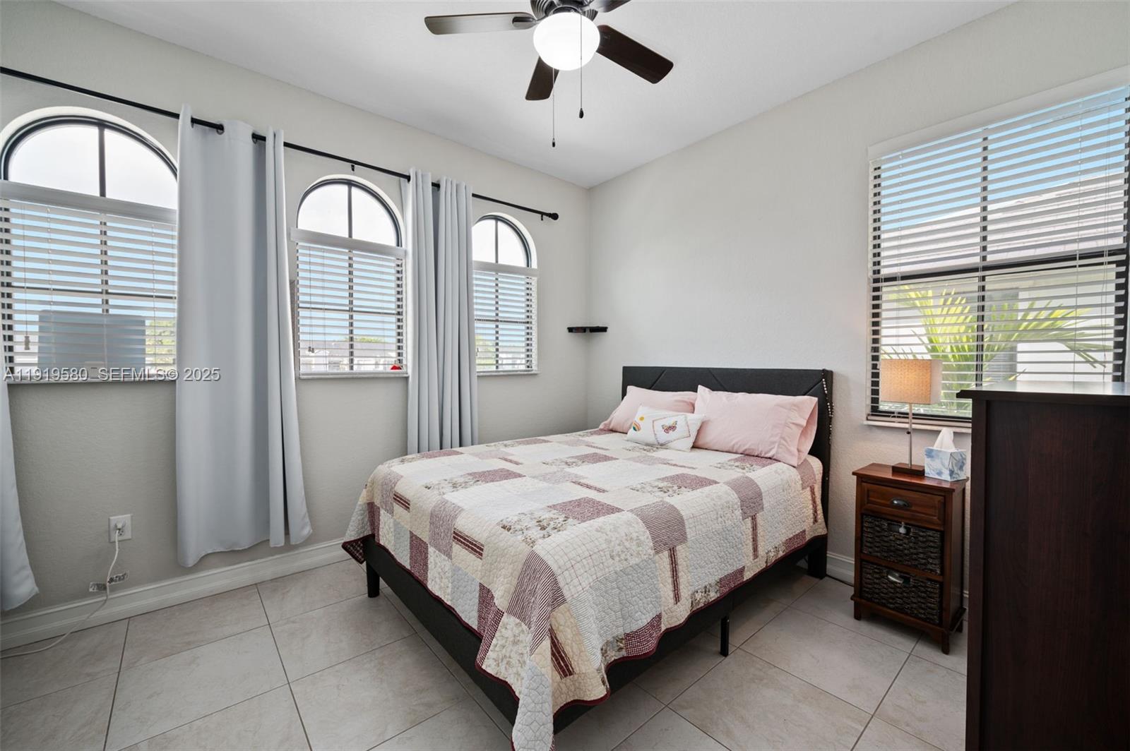445 Southwest 113th Lane Pembroke Pines, FL 33025 - Photo 15 of 26 a bedroom with a large bed and a chandelier