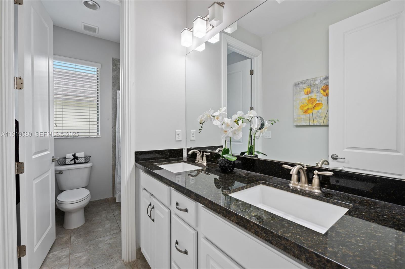 445 Southwest 113th Lane Pembroke Pines, FL 33025 - Photo 16 of 26 a bathroom with a granite countertop sink a toilet and a mirror