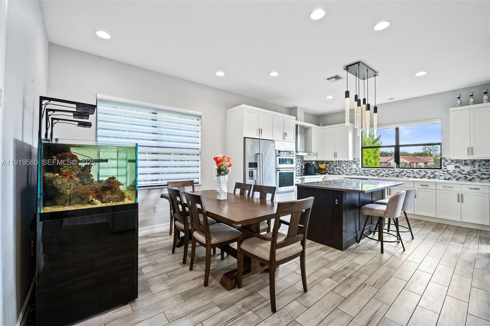445 Southwest 113th Lane Pembroke Pines, FL 33025 - Photo 6 of 26 a view of a dining room with furniture and wooden floor