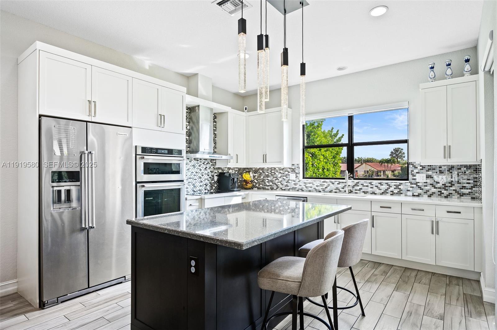 445 Southwest 113th Lane Pembroke Pines, FL 33025 - Photo 7 of 26 a kitchen with stainless steel appliances a sink stove refrigerator and cabinets