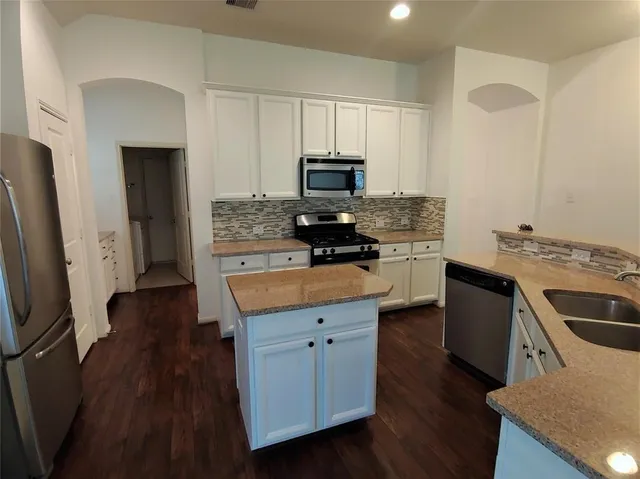 a kitchen with a stove a sink and a refrigerator
