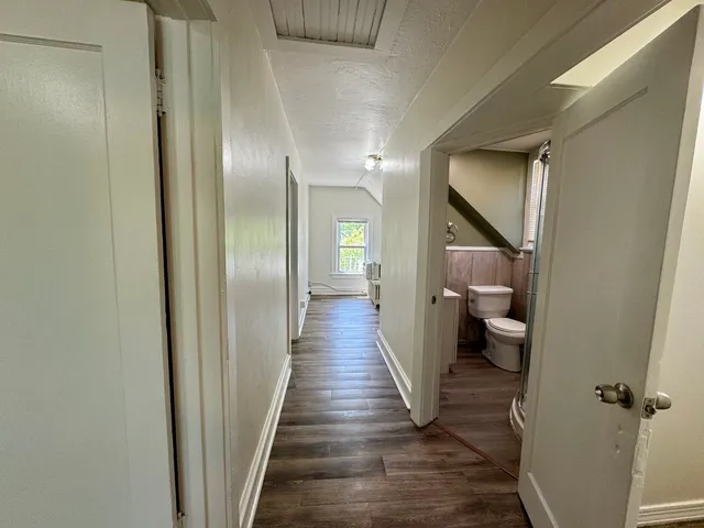 a view of a hallway with wooden floor and staircase