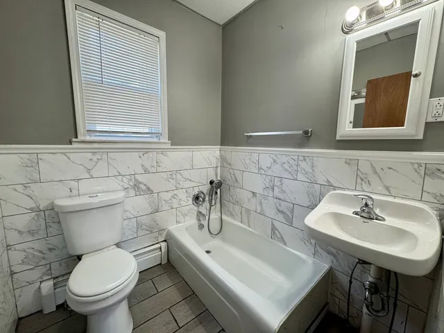 a bathroom with a toilet sink and mirror