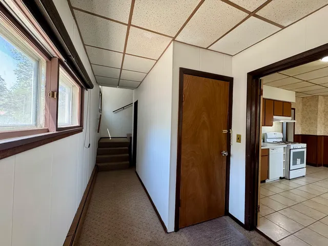 a view of a hallway with a dining table and chairs
