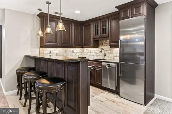 a kitchen with kitchen island a appliances and a refrigerator