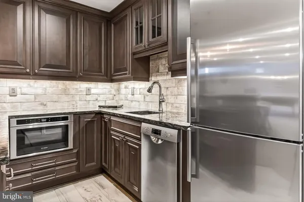 a kitchen with granite countertop a refrigerator and a sink