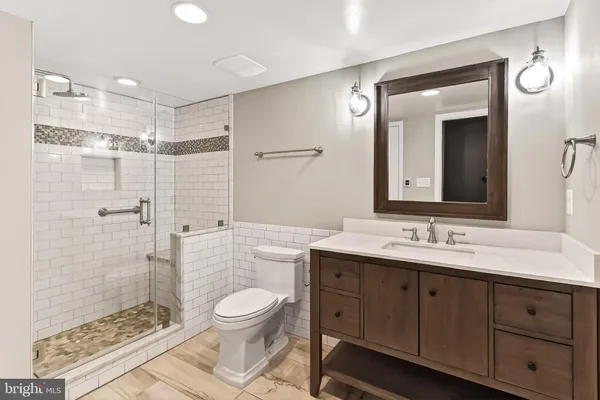 a bathroom with a double vanity sink toilet mirror and shower