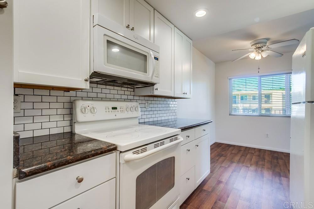 12643 Robison Boulevard, Unit 213 Poway, CA 92064 - Photo 19 of 49 a kitchen with granite countertop cabinets stainless steel appliances and a wooden floor