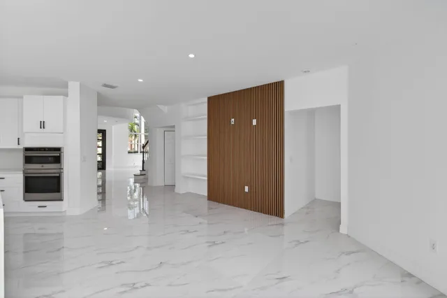 a kitchen with granite countertop a refrigerator and a stove top oven