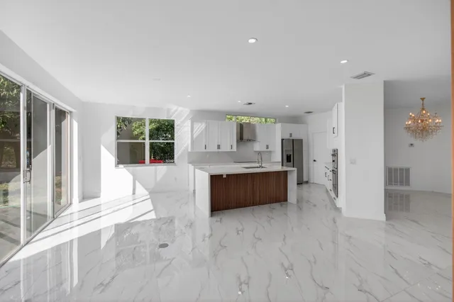 a kitchen with granite countertop a sink and white cabinets