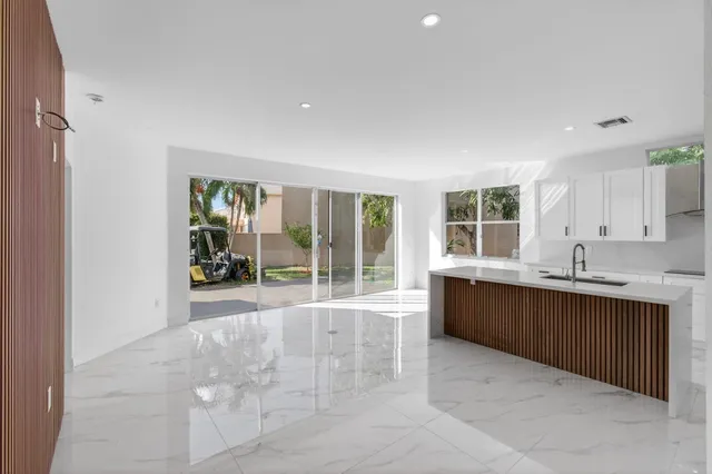 a large white kitchen with white cabinets and stainless steel appliances
