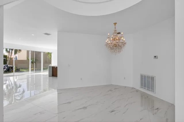a large white kitchen with a sink and refrigerator