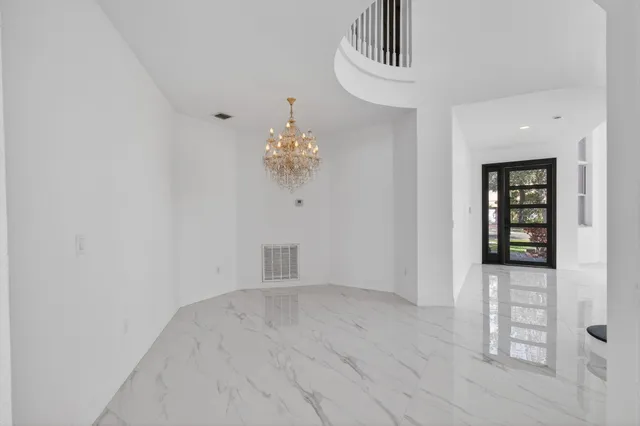 a large white kitchen with granite countertop a sink and cabinets
