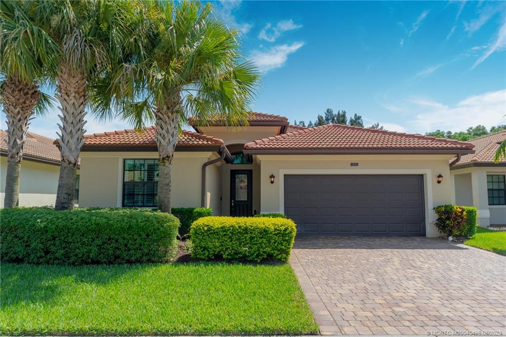 a front view of a house with a garden and plants