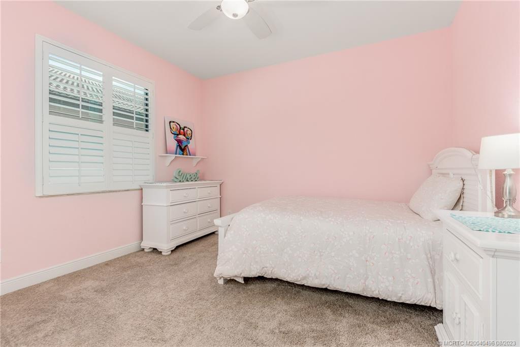 5891 Southeast Entry Court Stuart, FL 34997 - Photo 11 of 29 a bedroom with a bed and a window