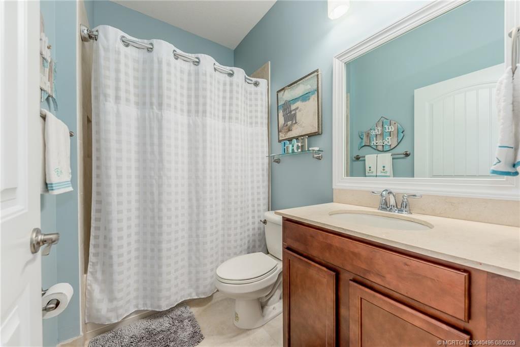5891 Southeast Entry Court Stuart, FL 34997 - Photo 14 of 29 a bathroom with a sink a toilet and shower