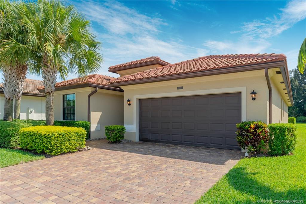 5891 Southeast Entry Court Stuart, FL 34997 - Photo 2 of 29 a front view of a house with garden