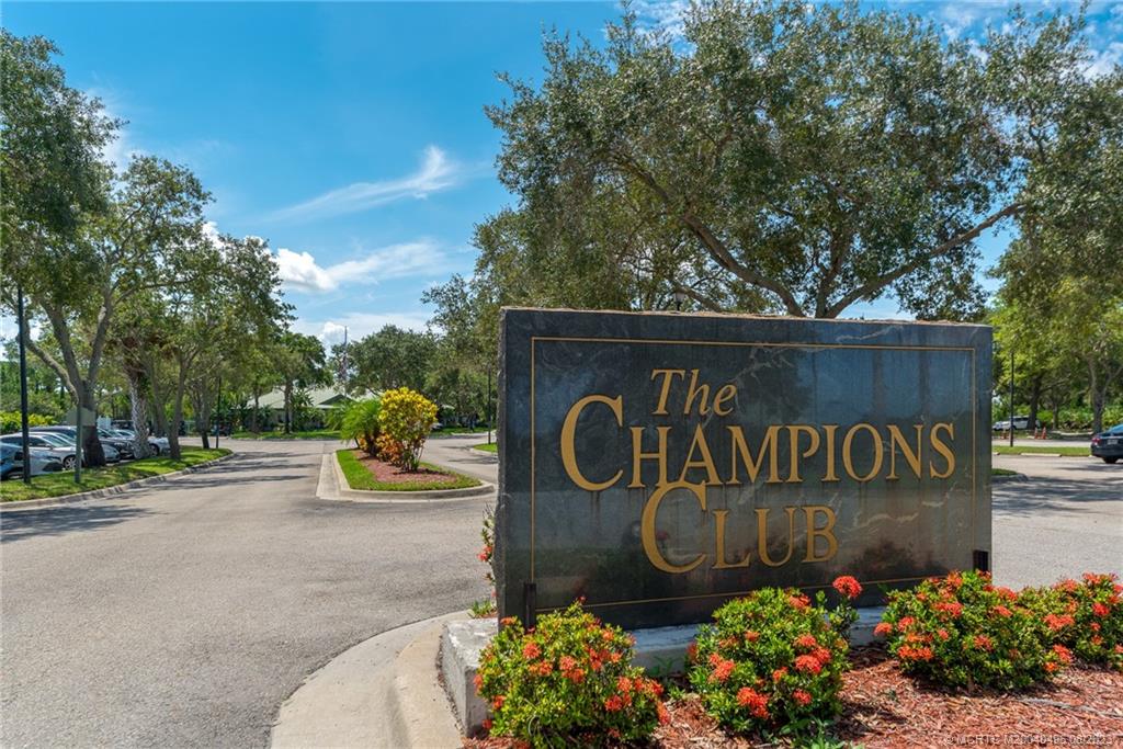 5891 Southeast Entry Court Stuart, FL 34997 - Photo 25 of 29 a sign that is sitting in front of flowers